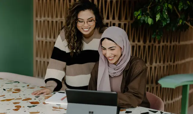 two women looking at a laptop