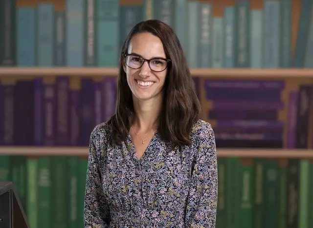 woman in blue dress wearing glasses