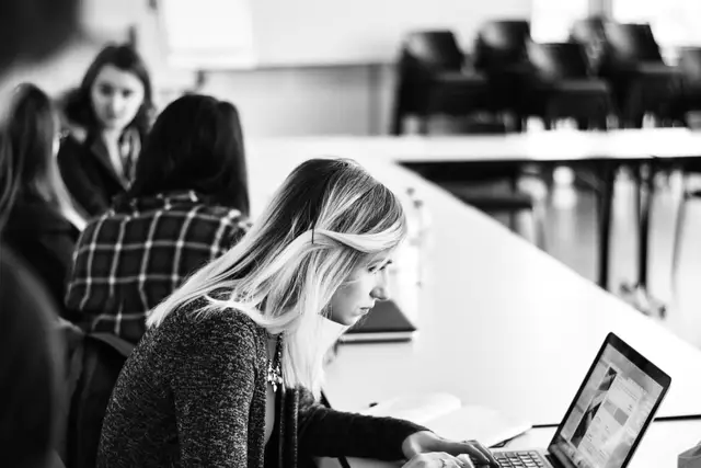 black and white photo of woman concentrating on a laptop