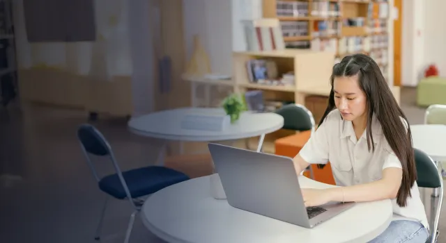 Female student working on her laptop in classroom